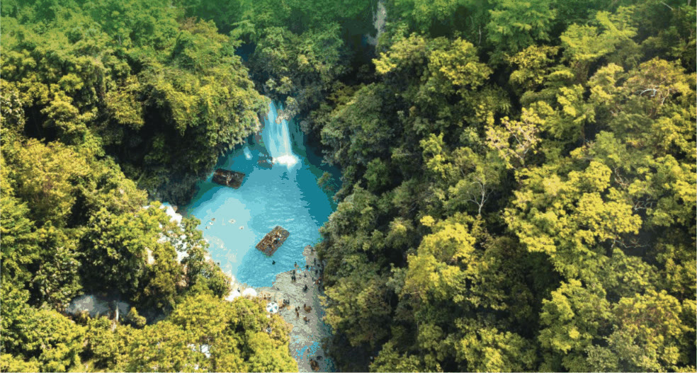 Aerial view of Kawasan Falls and its turquoise pool surrounded by forest