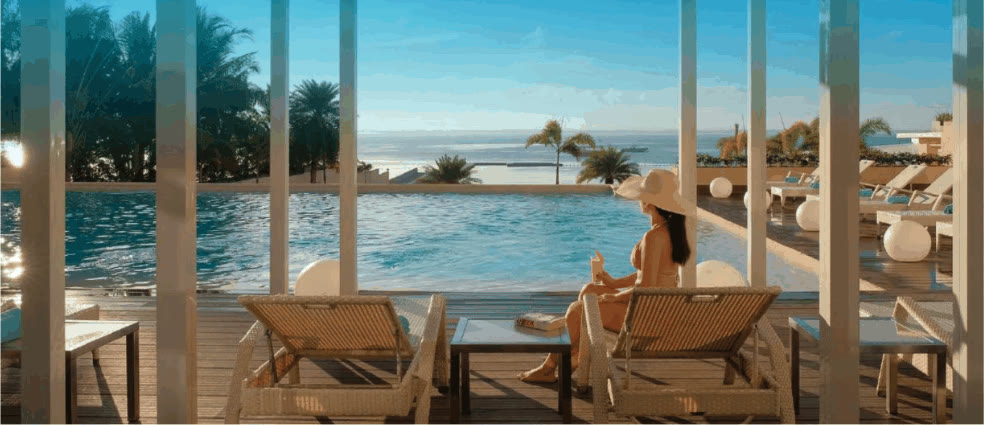 Guest relaxing in a poolside cabana overlooking the infinity pool and sea at BE Resort Mactan