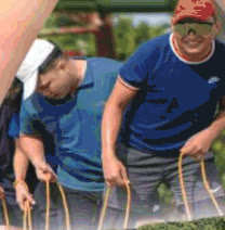 Guests in blue shirts during a rope team-building activity