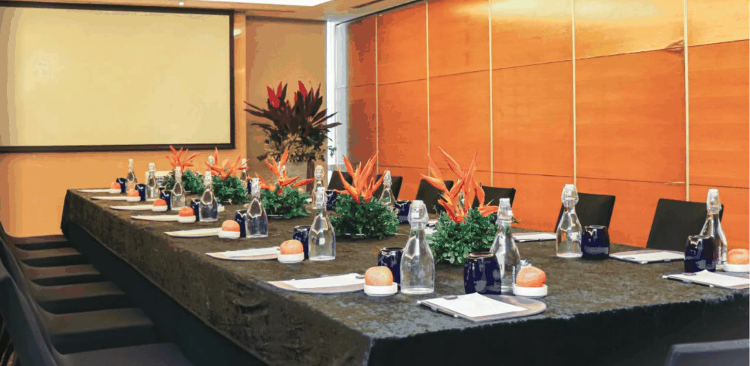Boardroom-style meeting table with orange heliconia centerpieces at Quest Hotel Conference Center Cebu