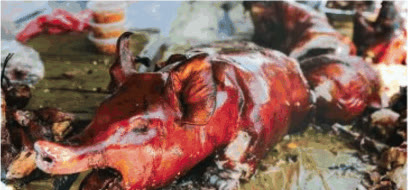 Whole roasted lechon on banana leaves